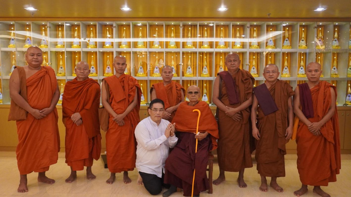 A group of men in orange robes
Description automatically generated